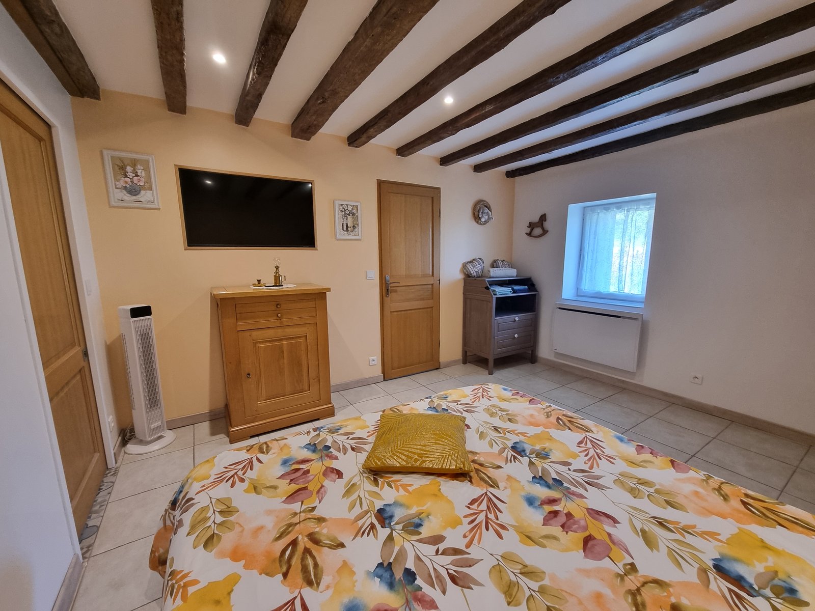 Chambre principale avec lit sous les poutres